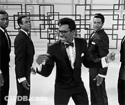 A Group Of Men In Tuxedos And Bow Ties Are Dancing GIF