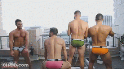 A Group Of Men In Underwear Are Dancing On A Rooftop GIF