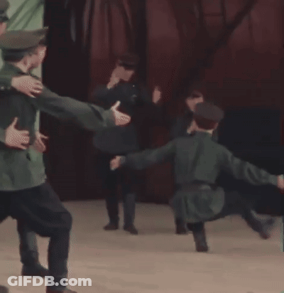 A Group Of Men In Uniforms Are Dancing On A Stage GIF