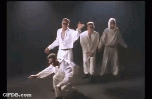 A Group Of Men In White Clothes Are Dancing Together On A Stage . GIF