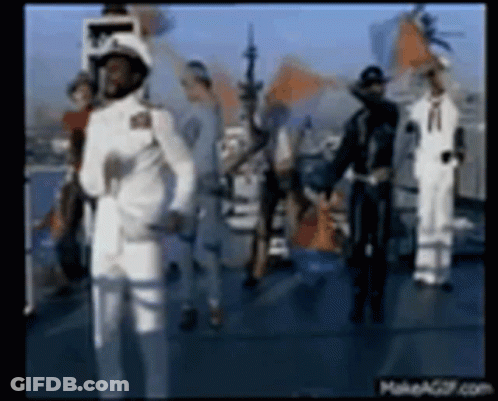 A Group Of Men In White Military Uniforms Are Standing On A Boat . GIF
