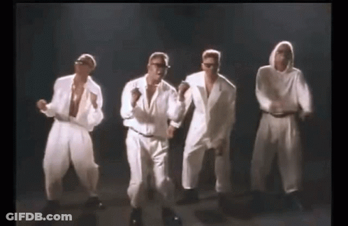 A Group Of Men In White Suits Are Dancing In A Line . GIF