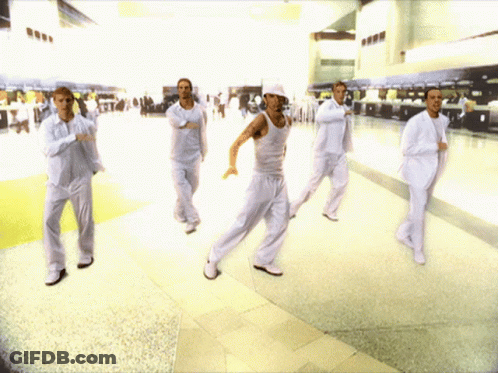 A Group Of Men In White Suits Are Dancing GIF