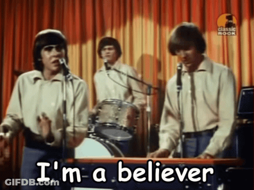A Group Of Men Singing Into Microphones With The Words " I 'M A Believer " Written On The Bottom GIF