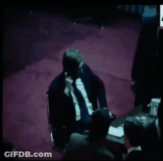 A Group Of Men Sitting Around A Table With A Chess Board On It GIF