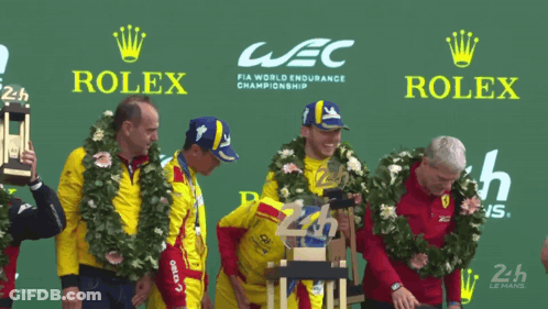 A Group Of Men Stand On A Podium With Rolex Advertisements Behind Them GIF