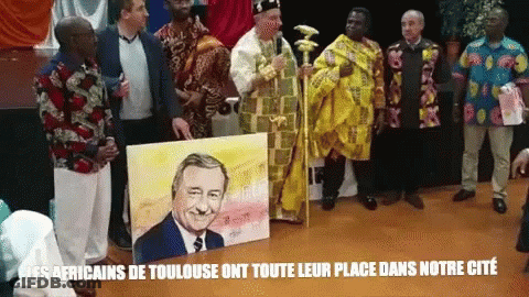 A Group Of Men Standing Around A Painting Of A Man With The Words Les Africains De Toulouse On The Bottom Right GIF