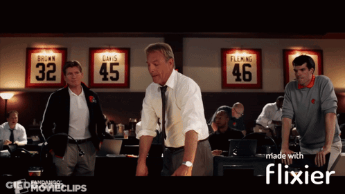 A Group Of Men Standing In Front Of A Wall With Jerseys On It That Say Brown Davis And Flaming GIF