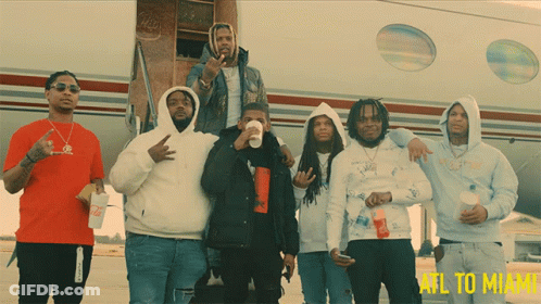 A Group Of Men Standing In Front Of An Airplane That Says Atl To Miami On The Bottom GIF