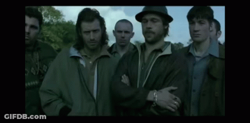 A Group Of Men Standing Next To Each Other In A Dark Room GIF