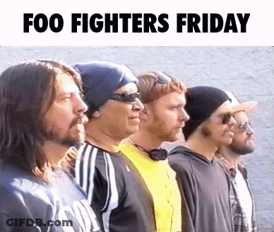 A Group Of Men Standing Next To Each Other In A Row With The Words Foo Fighters Friday Written Above Them . GIF