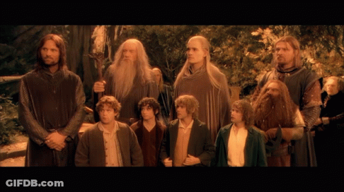 A Group Of Men Standing Next To Each Other With One Holding A Sword GIF
