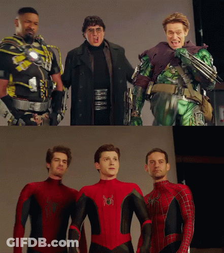 A Group Of Men Standing Next To Each Other With One Of Them Wearing A Spiderman Suit GIF