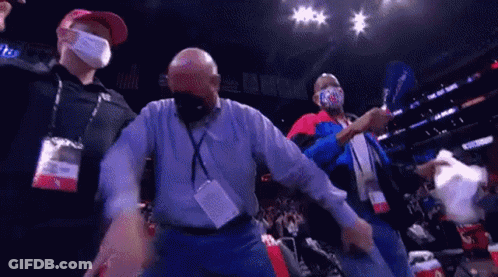 A Group Of Men Wearing Face Masks Are Standing In A Stadium . GIF