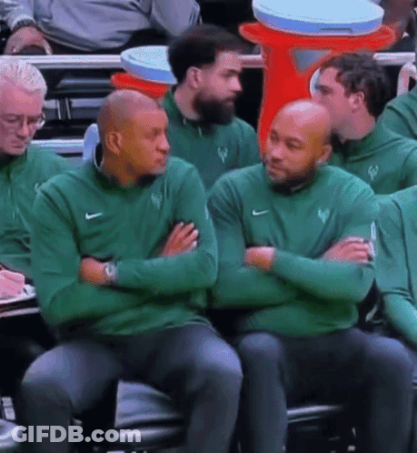 A Group Of Men Wearing Green Nike Sweatshirts Sit In A Stadium GIF