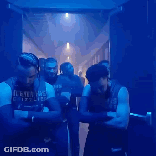 A Group Of Men Wearing Memphis Grizzlies Jerseys Are Standing In A Hallway GIF