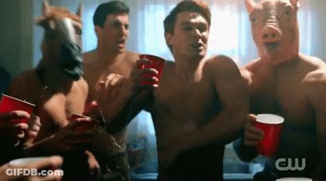A Group Of Men Wearing Pig Masks And Horse Masks Holding Red Cups GIF