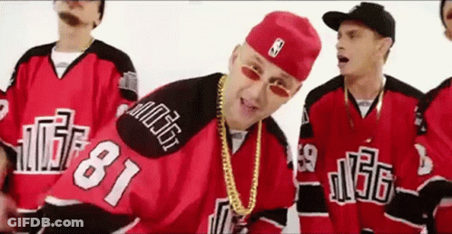 A Group Of Men Wearing Red And Black Hockey Jerseys And Hats Are Standing Next To Each Other . GIF