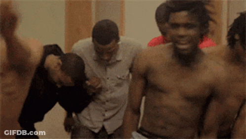 A Group Of Men Without Shirts Are Standing In A Room GIF