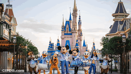 A Group Of Mickey Mouse And Friends Are Standing In Front Of The Castle GIF