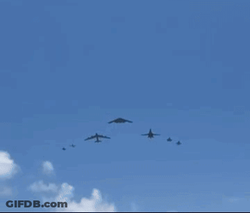 A Group Of Military Planes Are Flying In A Blue Sky . GIF