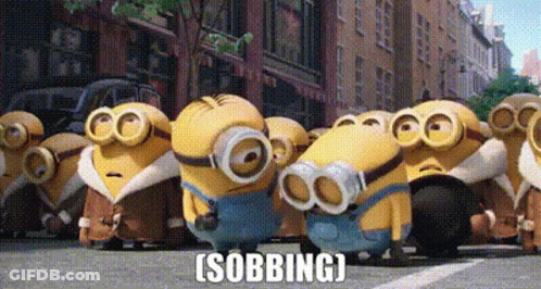 A Group Of Minions Are Standing In A Line On A City Street . GIF