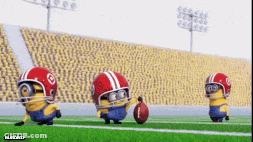 A Group Of Minions Wearing Football Helmets Are Playing Football On A Field GIF