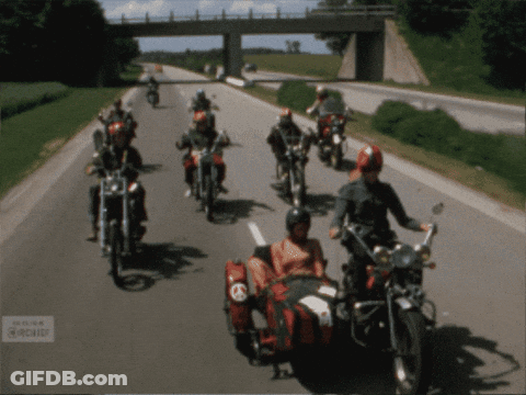 A Group Of Motorcycle Riders Are Riding Down A Highway GIF