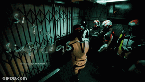 A Group Of Motorcycle Riders Are Standing In Front Of A Gate That Says ' Suspects ' GIF