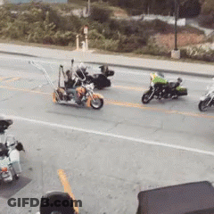 A Group Of Motorcycles Are Driving Down The Street GIF