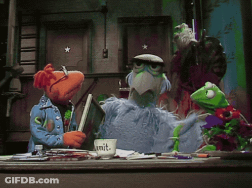 A Group Of Muppets Are Gathered Around A Desk With A Cup That Says Commit On It GIF