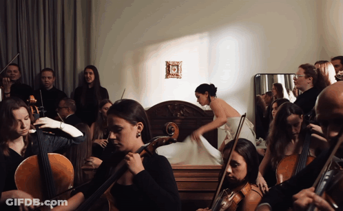 A Group Of Musicians Are Playing In A Room With A Woman In The Background GIF