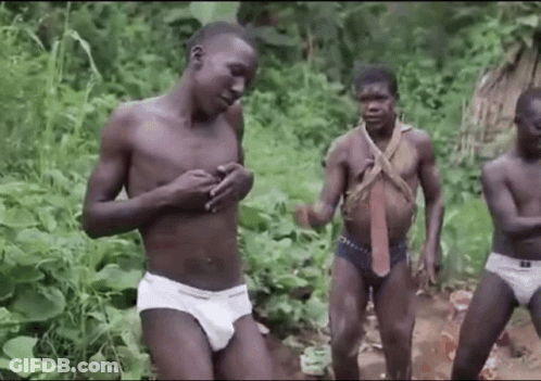 A Group Of Naked Men In Underwear Are Standing In A Forest . GIF