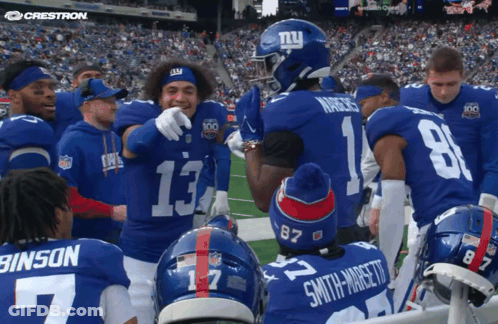 A Group Of New York Giants Players Huddle On The Field GIF