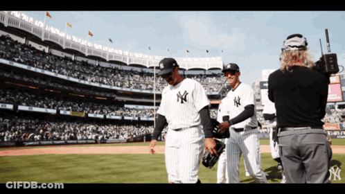 A Group Of New York Yankees Baseball Players Walking On The Field GIF