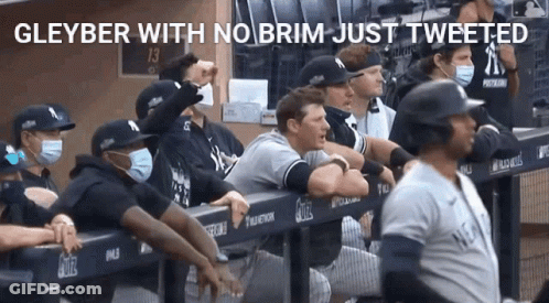 A Group Of New York Yankees Baseball Players Wearing Face Masks In A Dugout GIF