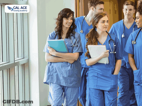 A Group Of Nurses Are Walking Down A Hallway With A Cal Ace Nursing Academy Logo Behind Them GIF
