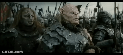 A Group Of Orcs Are Standing Next To Each Other In A Field Holding Spears . GIF