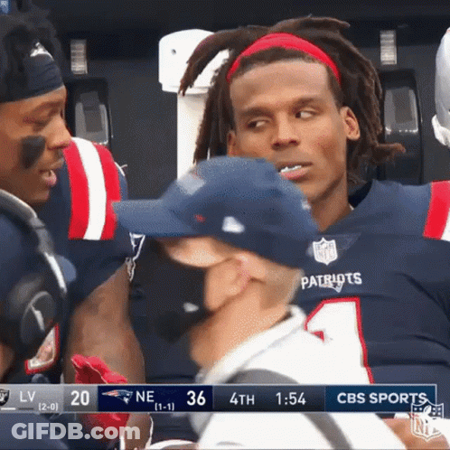 A Group Of Patriots Football Players Are Talking To A Referee . GIF