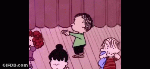 A Group Of Peanuts Characters Are Standing On A Stage Dancing . GIF