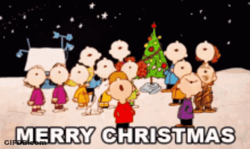 A Group Of Peanuts Characters Standing In Front Of A Christmas Tree With The Words Merry Christmas Above Them GIF