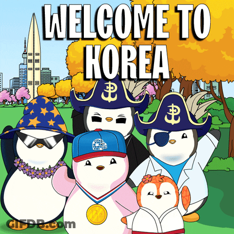 A Group Of Penguins Are Standing In Front Of A Sign That Says " Welcome To Korea " GIF