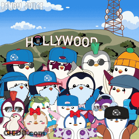 A Group Of Penguins Posing For A Picture In Front Of A Sign That Says Hollywood GIF