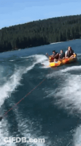 A Group Of People Are Being Towed By A Boat In A Lake GIF