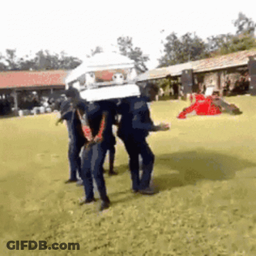 A Group Of People Are Carrying A Coffin On Their Heads GIF