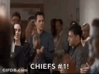A Group Of People Are Clapping In A Room And A Man Is Saying `` Chiefs # 1 '' . GIF