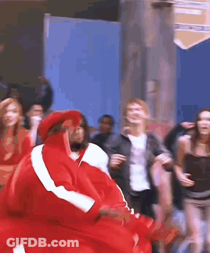A Group Of People Are Dancing And One Of Them Is Wearing A Red Jacket GIF