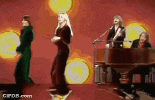 A Group Of People Are Dancing And Singing On A Stage GIF