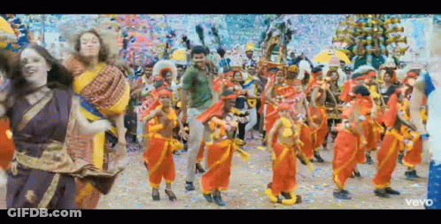 A Group Of People Are Dancing In A Colorful Parade . GIF