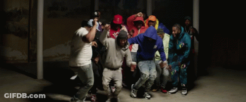 A Group Of People Are Dancing In A Dark Room And One Of Them Is Wearing A Hoodie That Says ' A ' GIF